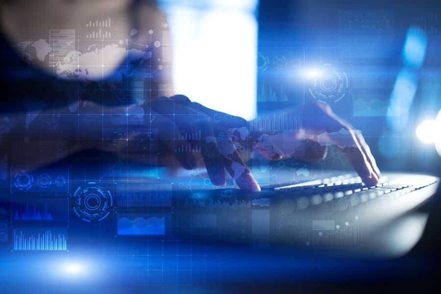 Image of a man typing on a laptop with transparent digital images and blue hue 